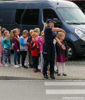 Policjantka wraz z dziećmi przed wejściem na przejście dla pieszych