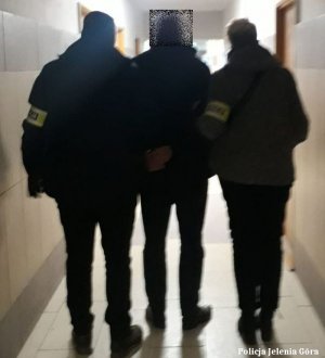 Policjanci prowadzą zatrzymanego