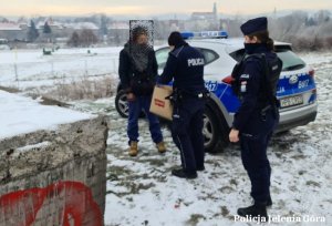 Policjanci przekazują torbę z odzieżą