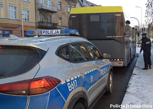 Policjant sprawdza czy pasażerowie  stosują się do obowiązku zasłaniania ust i nosa