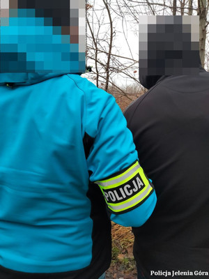 Policjant prowadzi zatrzymanego