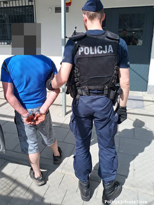 Policjant prowadzi zatrzymanego