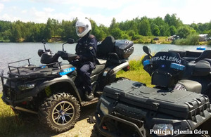 Policjant na quadzie, obok quad straży leśnej w trakcie kontroli kąpielisk