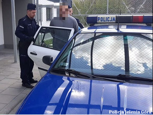 Policjanci z zatrzymanym przy radiowozie