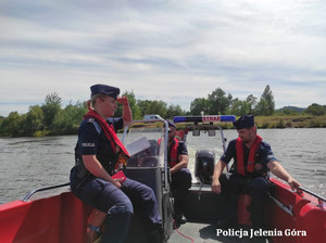 policjanci i strażacy na łodziach sprawdzają zbiornik wodny