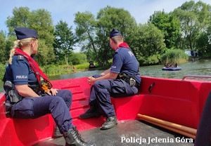 policjanci i strażacy na łodziach sprawdzają zbiornik wodny