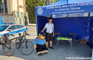 Policjant z patrolu rowerowego pod namiotem policyjnym