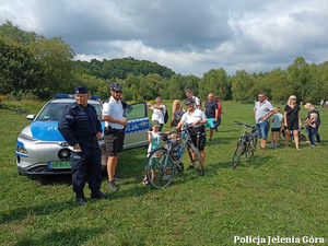 Policjanci, w tle radiowóz oraz uczestnicy pikniku