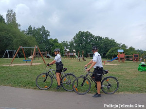 policjanci na rowerach na placu zabaw