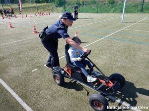 Policjantka z dzieckiem w miasteczku ruchu drogowego