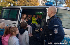 policjanci z dziećmi przy radiowozie