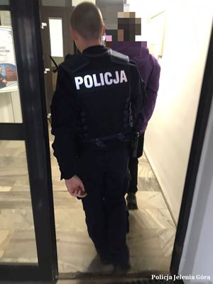 Policjant prowadzi zatrzymanego