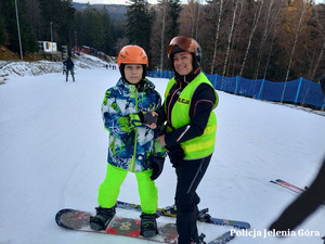 Policjantka z chłopcem na snowboardzie