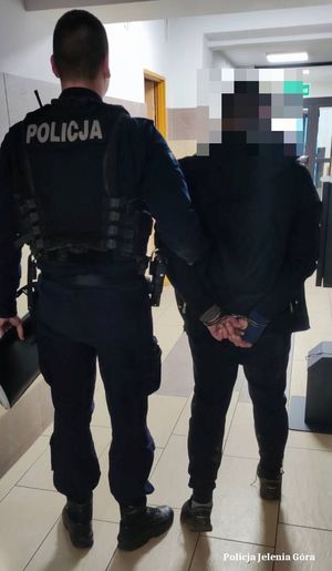 Policjant prowadzi zatrzymanego