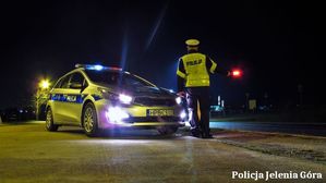 Policjant przy radiowozie na drodze