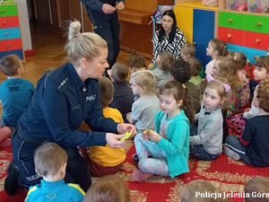 policjantka rozdaje dzieciom odblaski