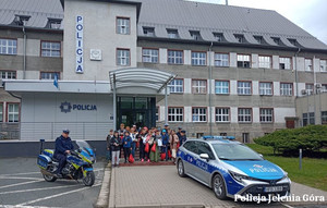 Młodzież z policjantami pod budynkiem komendy