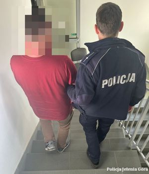 Policjant prowadzi zatrzymanego