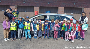 Policjanci wraz dziećmi, w tel radiowóz