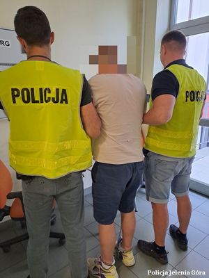 Policjanci prowadzą zatrzymanego