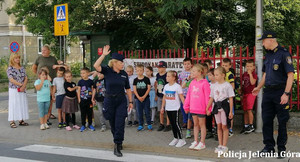 Mundurowi z dziećmi na przejściu dla pieszych