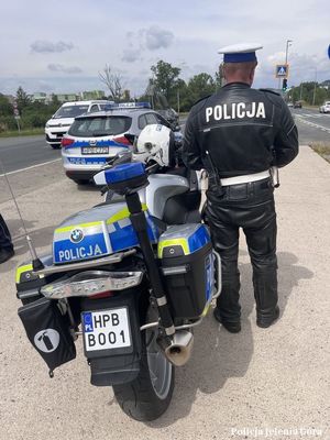 Policjant stojący przy policyjnym motocyklu