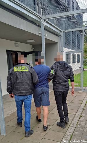 Policjanci prowadzą zatrzymanego