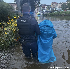 Policjant ewakuuje mieszkankę