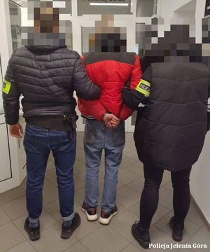 Policjanci prowadzą zatrzymanego