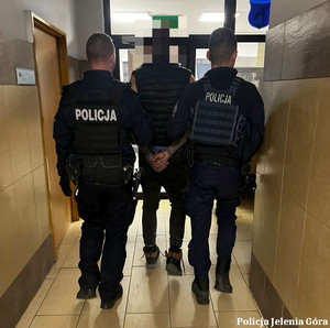 Policjanci prowadzą zatrzymanego