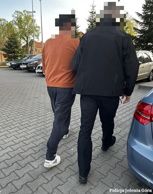 policjant prowadzi zatrzymanego