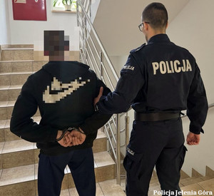 Policjant prowadzi zatrzymanego