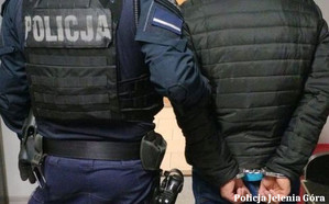 policjant prowadzi zatrzymanego