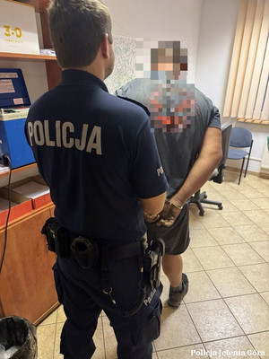 Policjant prowadzi zatrzymanego