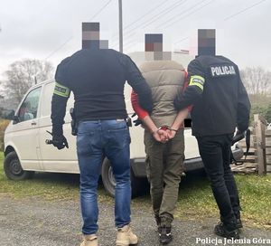 Policjanci prowadzą zatrzymanego