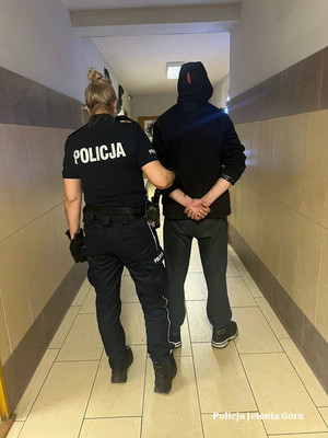 policjantka doprowadza podejrzewanego