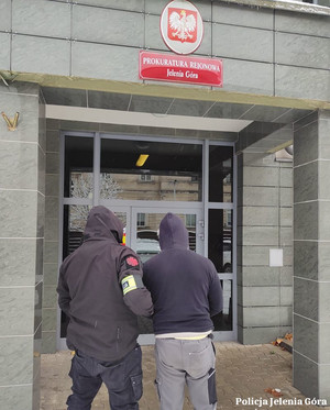 Policjant prowadzi zatrzymanego