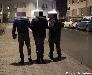 Policjanci prowadzą zatrzymanego