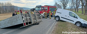 auto w rowie i przewrócona przyczepka, na miejscu strażacy
