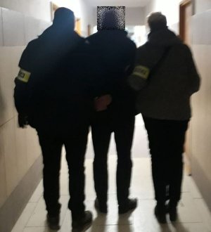 Policjanci prowadzą mężczyznę podejrzanego o kradzież pojazdu oraz udzielanie narkotyków