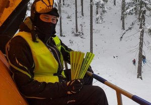 Policjant z patrolu narciarskiego z odblaskami na wyciągu