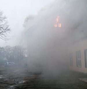 Policyjny radiowóz i płonący budynek