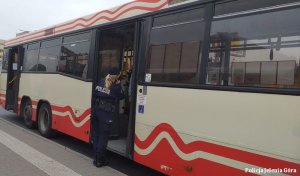 Policjantka sprawdza w autobusie  MZK przestrzeganie obostrzeń