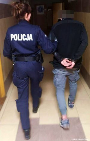 Policjantka prowadzi mężczyznę podejrzanego o kradzież