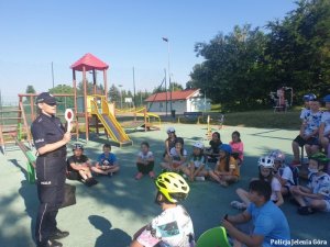 Policjantka rozmawia a uczniami na temat bezpieczeństwa w ruchu drogowym