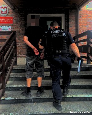 funkcjonariusze prowadzą wandala z komisariatu I Policji w Jeleniej Górze