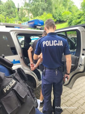 Policjanci doprowadzają zatrzymanego