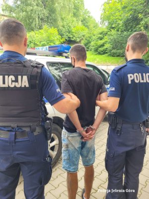 Policjanci doprowadzają zatrzymanego