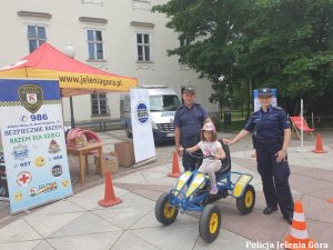 Policjantka i strażnik miejskim prezentuj najmłodszym miasteczko ruchu drogowego